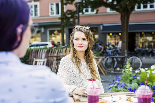 Женщины сидят в кафе на тротуаре — стоковое фото