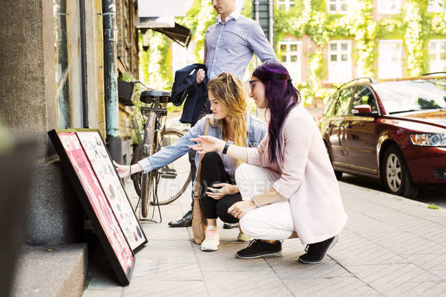 Women looking at signboard — Stock Photo