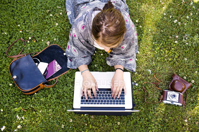 Happy woman using laptop at park — Stock Photo