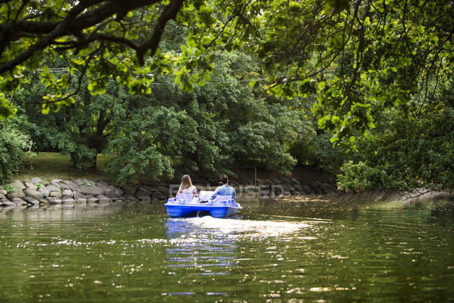 Man and woman pedal boating — Stock Photo