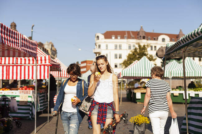 Girls holding apples and walking — Stock Photo