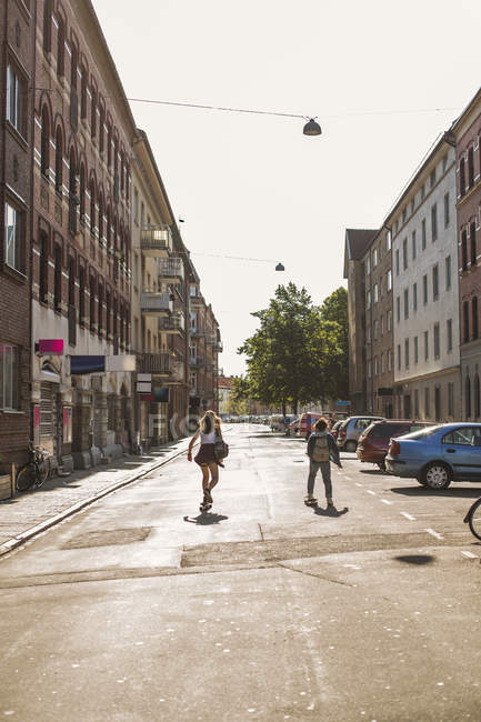 Vue arrière des filles skateboard dans la rue — Photo de stock