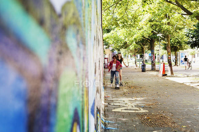 Les adolescentes skateboard par mur — Photo de stock