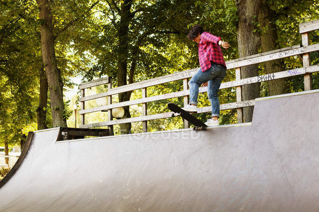 Девушка, стоящая на скейтборде на рампе — стоковое фото