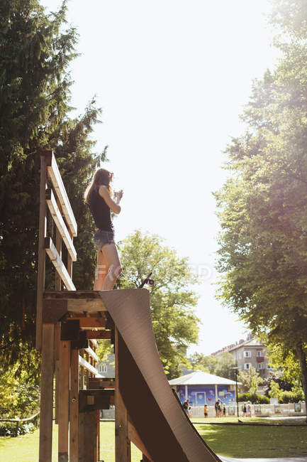 Teenage girl standing on ramp at park — Stock Photo