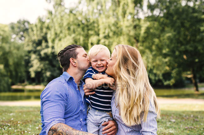 Parents kissing happy son — Stock Photo