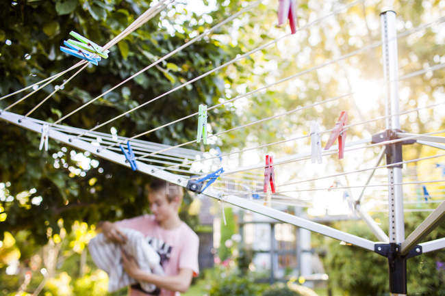 Clothespins on clothesline with boy in background — Stock Photo
