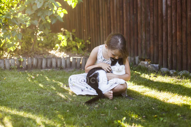Девушка играет с котом на заднем дворе — стоковое фото