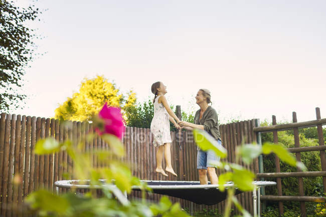 Mother and daughter jumping on trampoline — Stock Photo