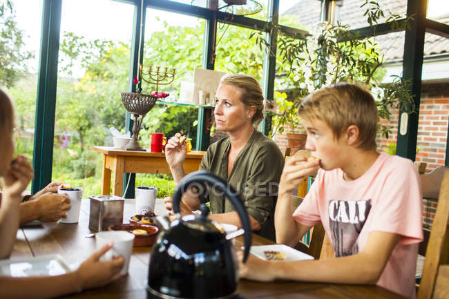 Famille de quatre personnes prenant le petit déjeuner — Photo de stock