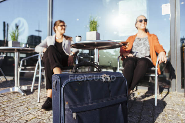 Businesswomen sitting on chairs with luggage — Stock Photo