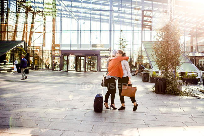 Businesswomen embracing outside station — Stock Photo