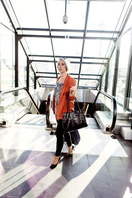 Femme d'affaires marchant par escalator — Photo de stock