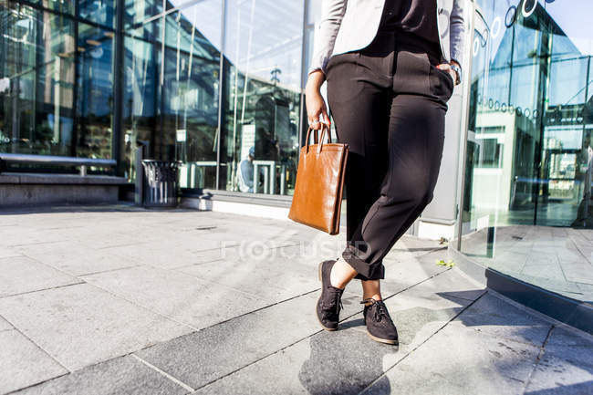 Businesswoman standing outside with bag — Stock Photo