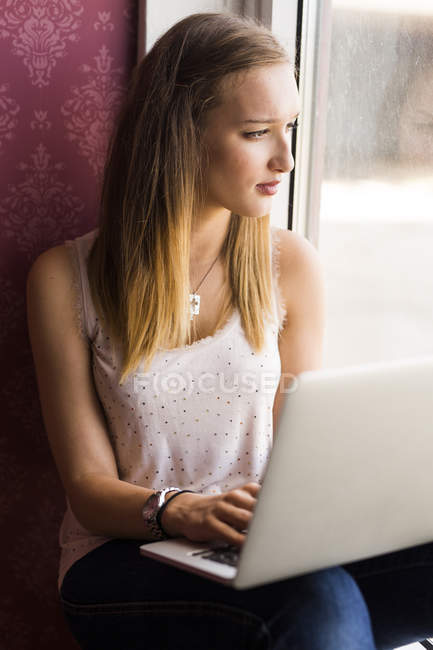 Modelo adolescente usando laptop - foto de stock