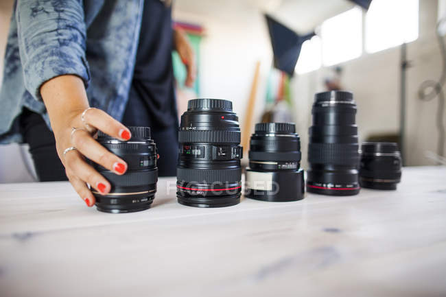 Photo assistant arranging various lenses — Stock Photo