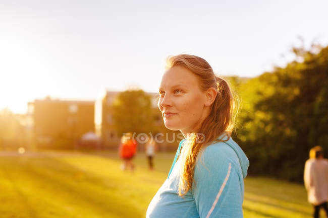 Athlète féminine au parc au coucher du soleil — Photo de stock