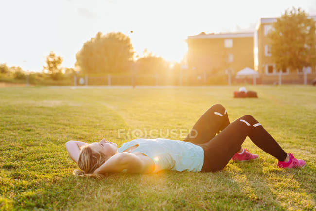Fitte Frau im Gras liegend — Stockfoto