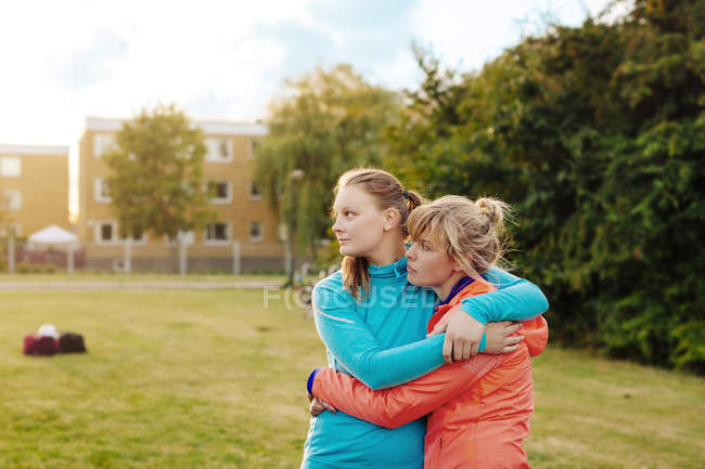Glückliche Frauen, die sich auf dem Feld umarmen — Stockfoto