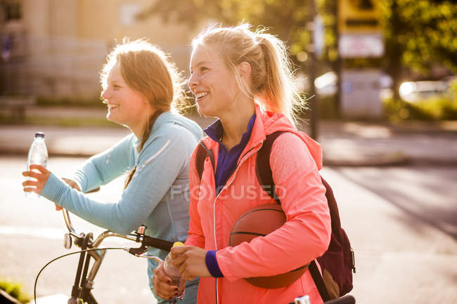 Amici donne in piedi in bicicletta — Foto stock