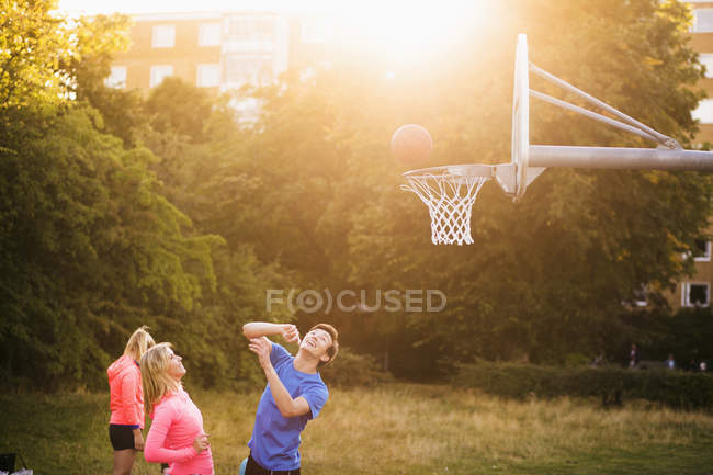 Amigos jugando baloncesto en el parque - foto de stock