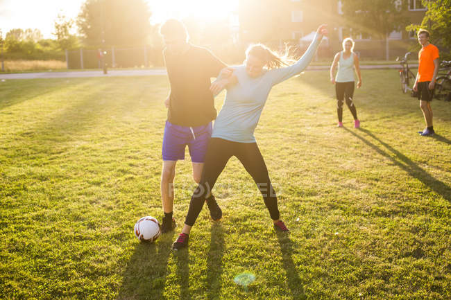Друзья играют в футбол в парке — стоковое фото
