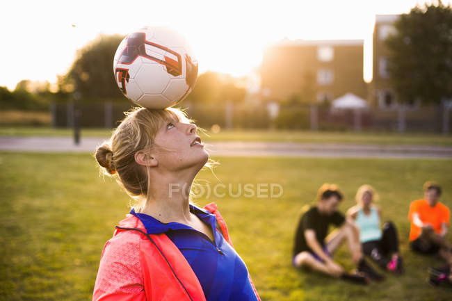 Woman balancing ball on head — Stock Photo