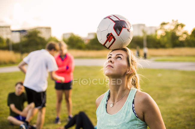 Donna bilanciamento palla sulla testa — Foto stock