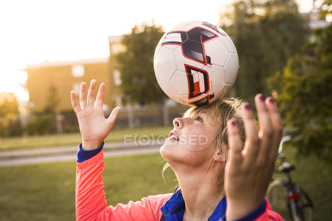 Donna bilanciamento palla sulla testa — Foto stock