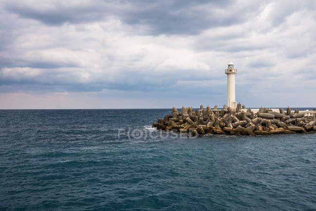 Faro en el mar en Naha Port - foto de stock