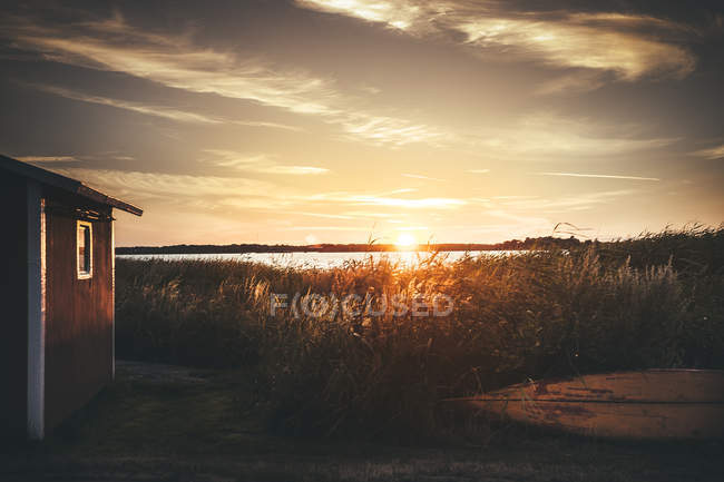 Cabine en rondins contre le ciel au coucher du soleil — Photo de stock
