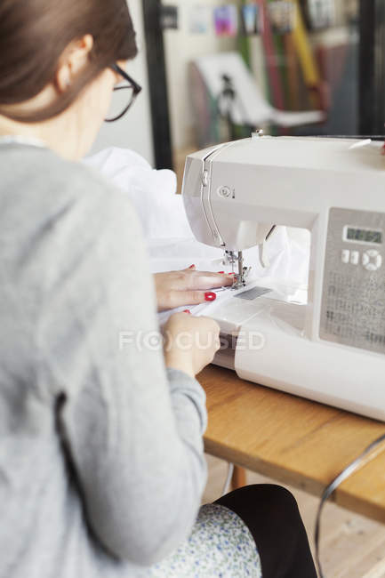 Модный дизайнер с помощью швейной машины — стоковое фото