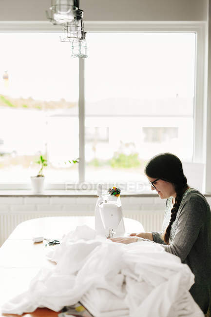 Fashion designer working on sewing machine — Stock Photo