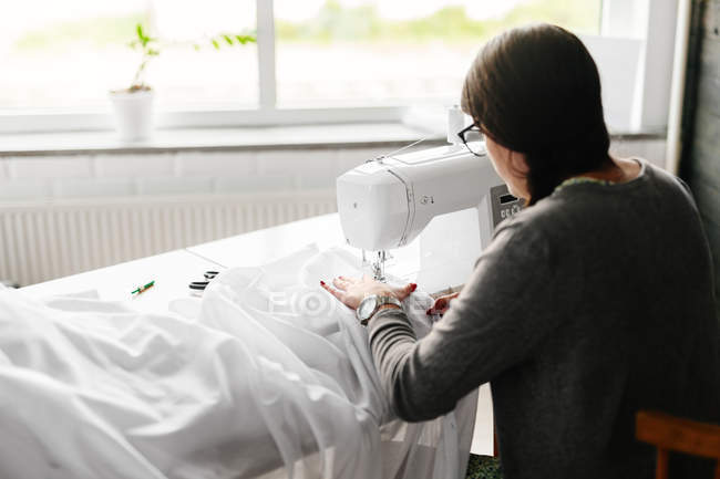 Créateur de mode travaillant sur une machine à coudre — Photo de stock