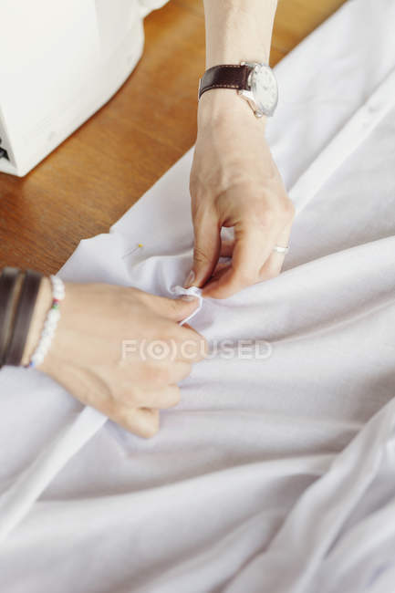 Männlicher Designer steckt weißes Textil an — Stockfoto