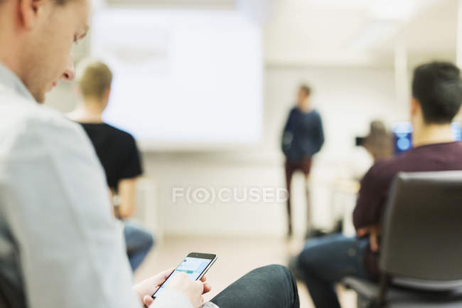 Midsection of student holding smart phone — Stock Photo