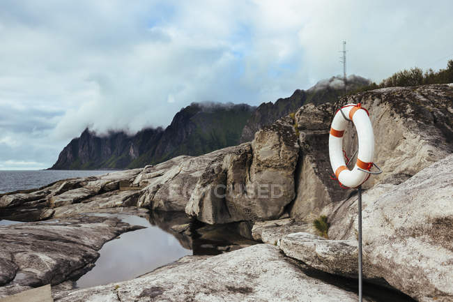 Life belt hanging on pole at island — Stock Photo