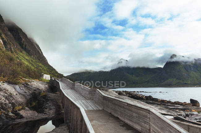 Uferpromenade führt in die Berge — Stockfoto