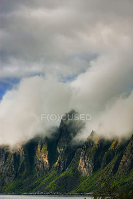 Nubes que cubren montañas rocosas - foto de stock