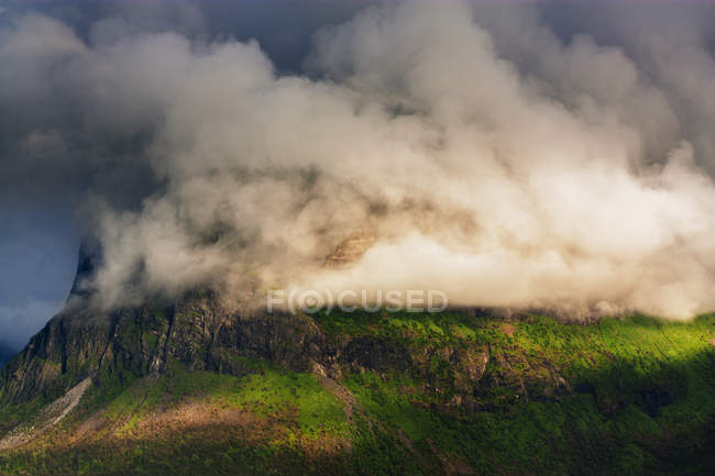 Nubes que cubren montañas rocosas - foto de stock