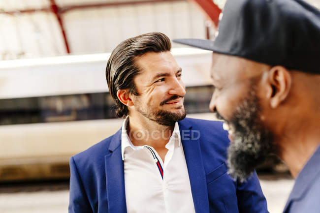 Empresários felizes em pé na estação ferroviária — Fotografia de Stock