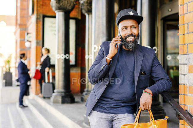 Homme souriant utilisant un téléphone intelligent — Photo de stock