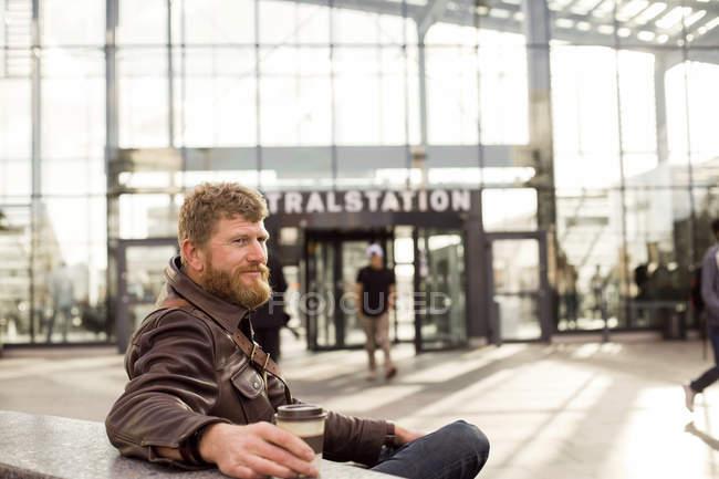Man sitting outside central station — Stock Photo