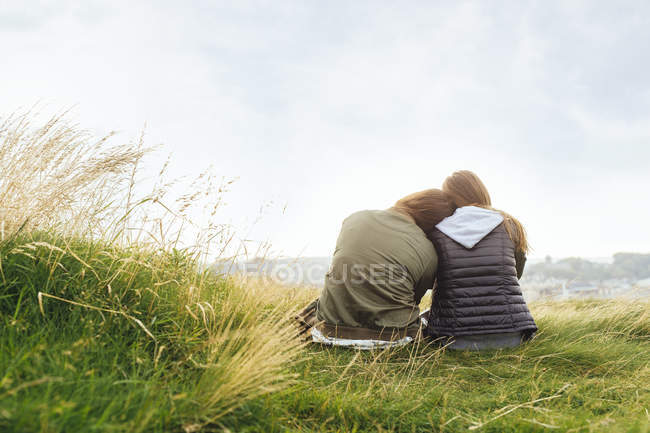 Amigos do sexo feminino relaxando na colina — Fotografia de Stock
