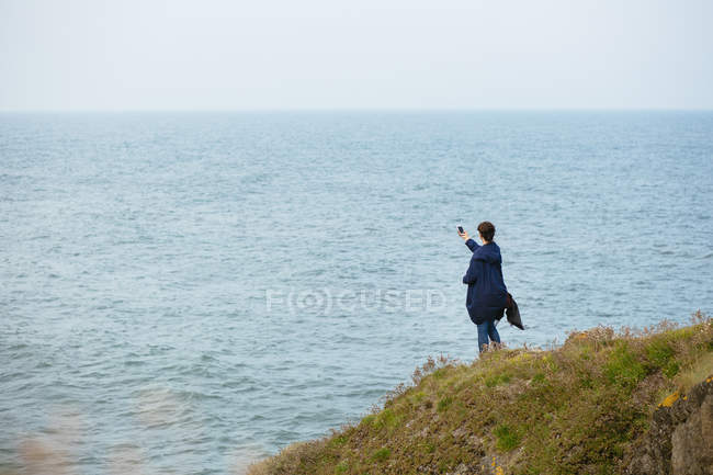 Woman photographing through smart phone — Stock Photo