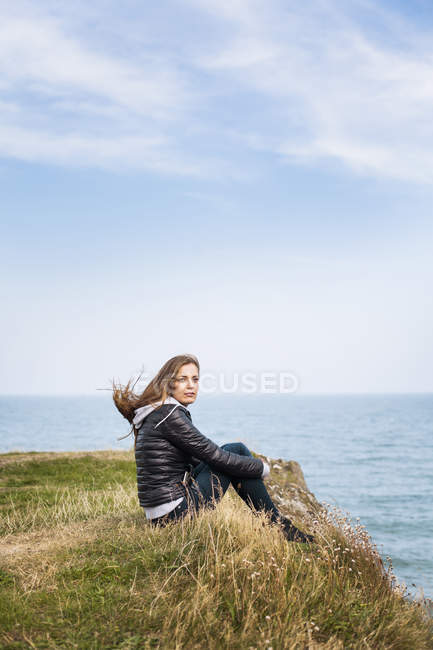 Жінка сидить на пагорбі — стокове фото