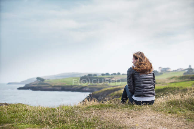 Woman sitting on hill — Stock Photo