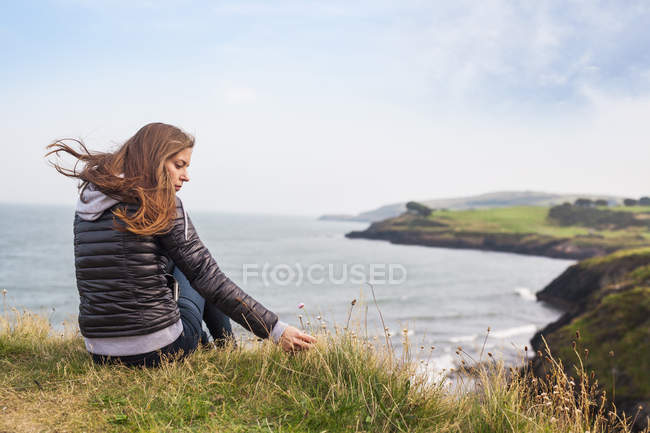 Mujer sentada en la colina - foto de stock