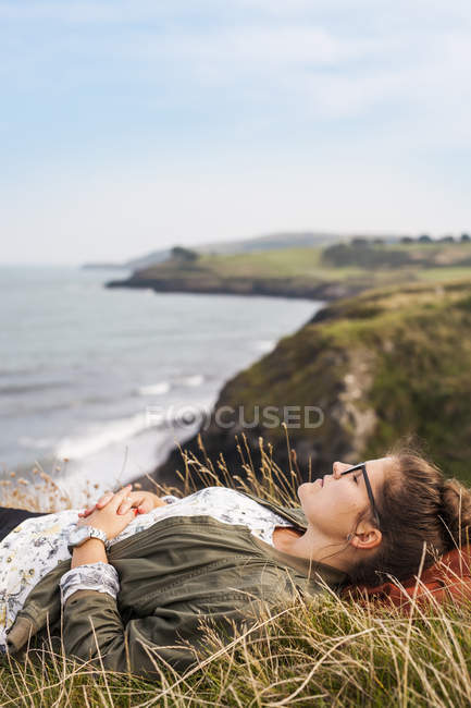 Женщина спит на травянистом холме — стоковое фото