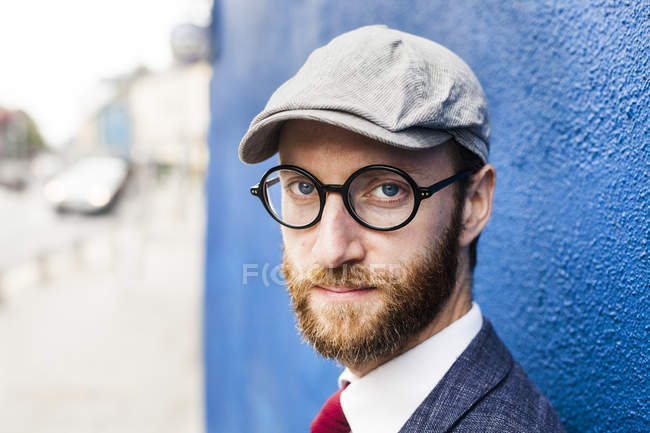 Selbstbewusster Mann an blauer Wand — Stockfoto